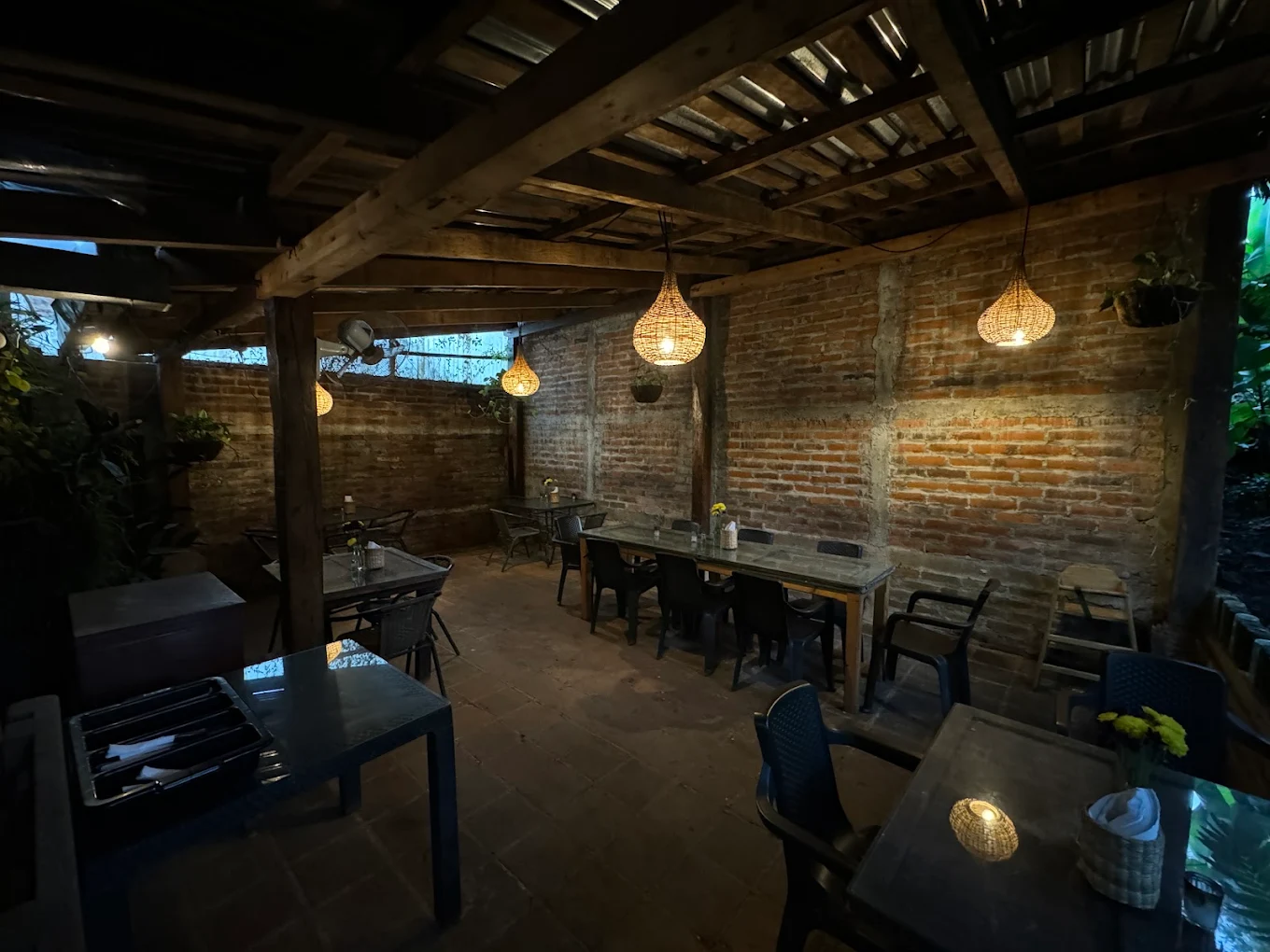Interior del restaurante Piccolo Giardino - paredes de ladrillo, vigas de madera, lámparas colgantes
